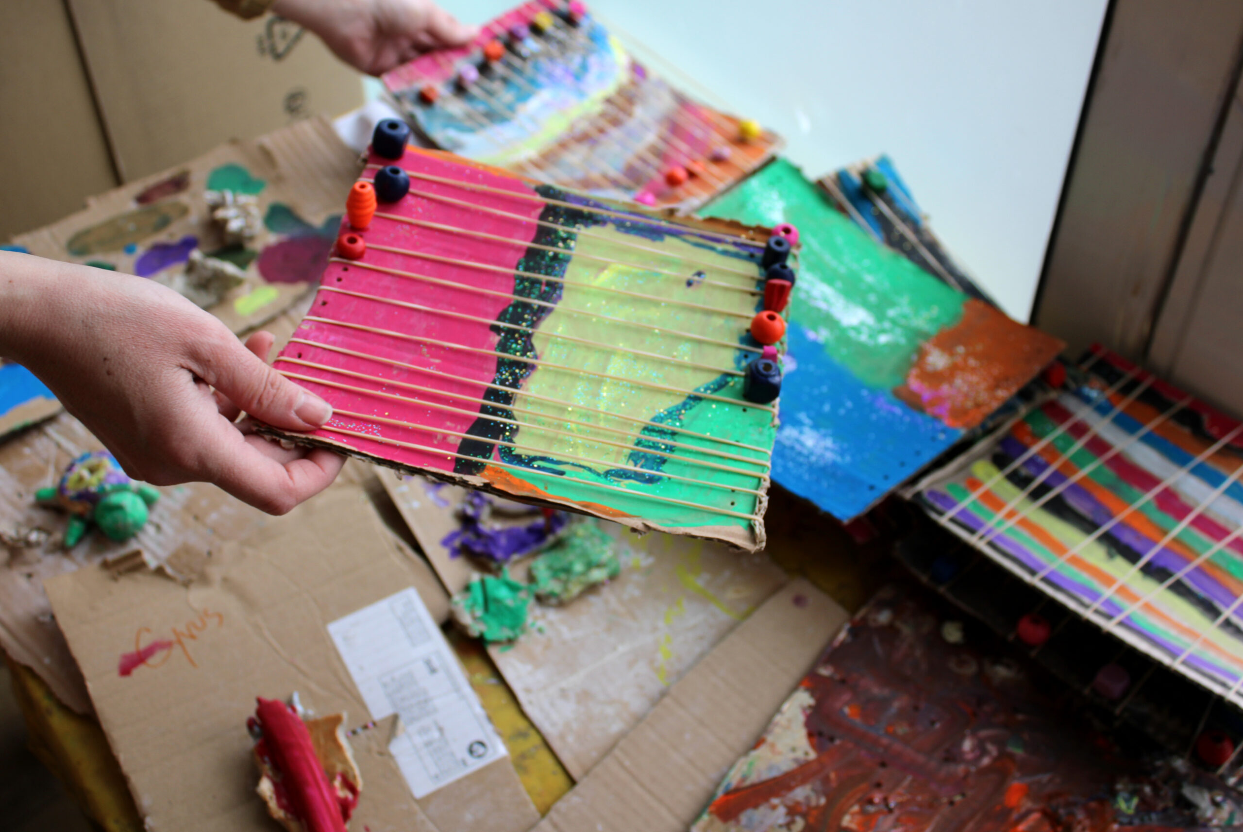 main qui tient un Instrument peint et coloré fabriqué par un enfant
